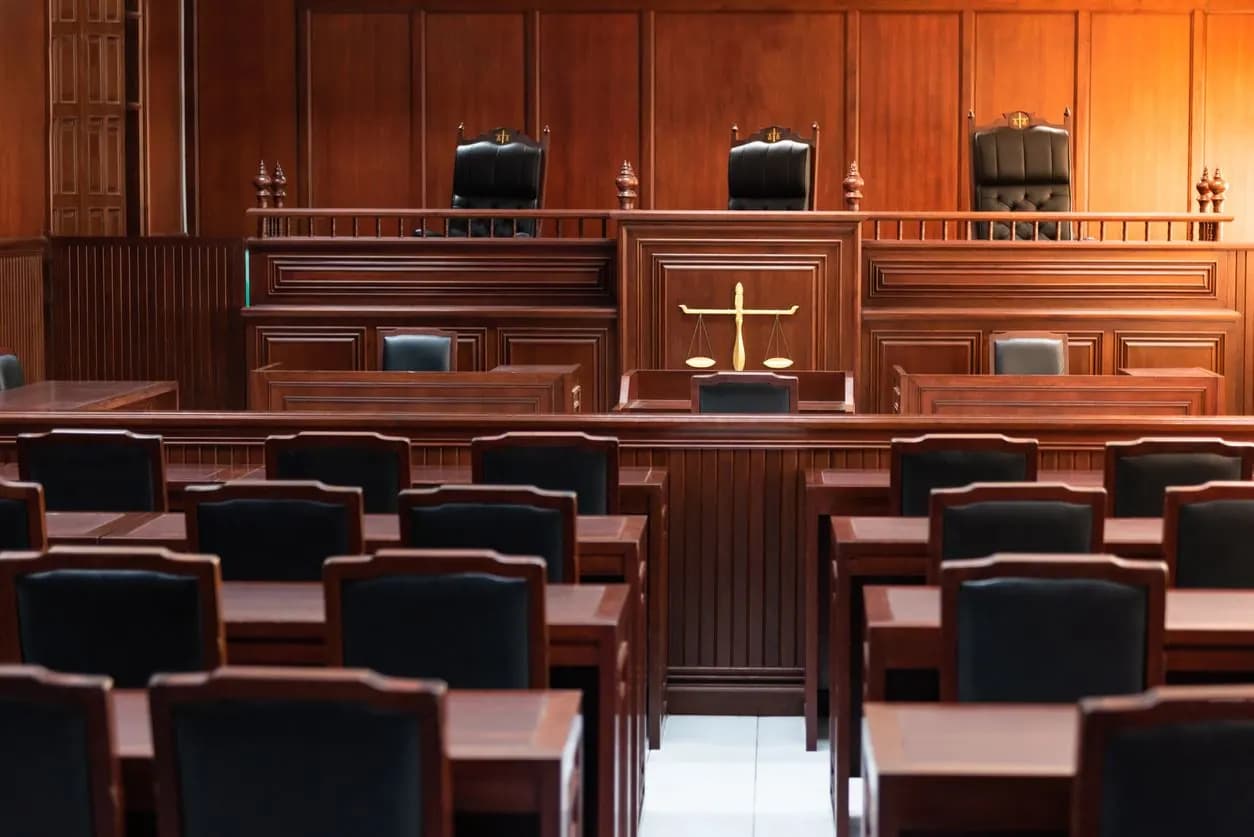 An empty courtroom with the judge's bench and counsel tables